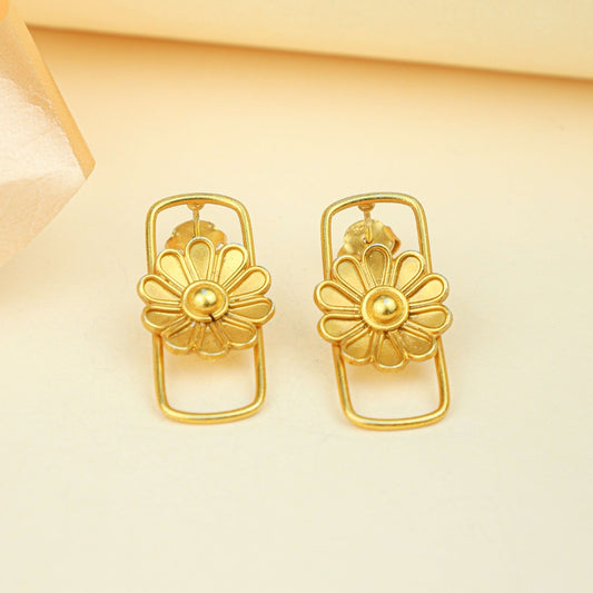Pair of gold floral earrings on a beige background